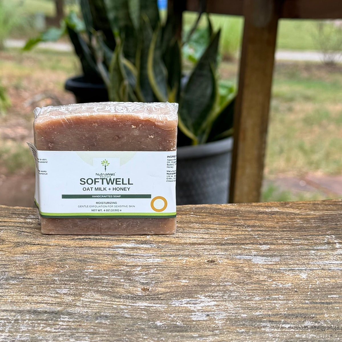 SoftWell Oat Milk + Honey soap bar on a wooden porch swing